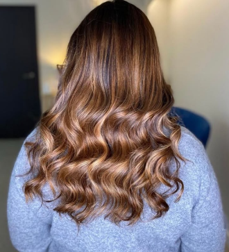 Melena larga con ondas en tono castaño cobrizo cálido