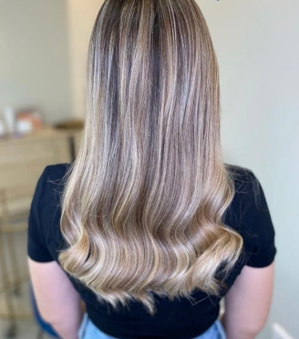Melena rubia con balayage y ondas suaves en las puntas